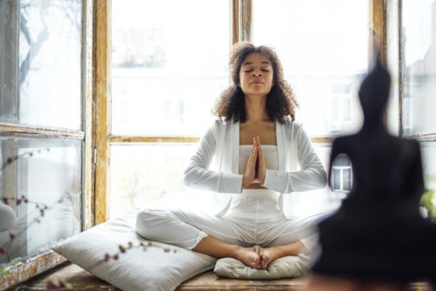 Young adult happy fit slim healthy African American ethnic woman wearing white clothes sitting in