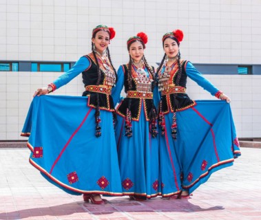 NUKUS, UZBEKISTAN - MAY 6, 2019: Three traditionally dressed folk dancers in Nukus, Uzbekistan,
