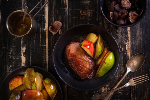 Roasted duck breast with golden crispy skin served with baked apples and chestnuts. Served on a
