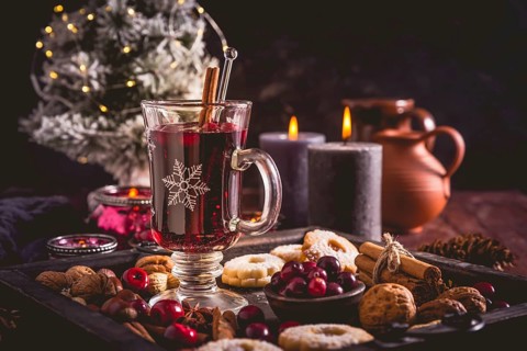 Mulled wine with cranberry and spices, Christmas cookies and candles