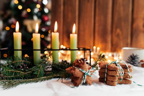 Christmas decorations with candles, fir branches and gingerbread.