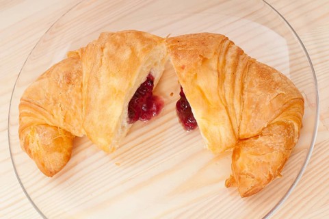 Fresh baked croissant French brioche filled with berries jam