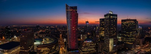 A panorama picture of the sun setting over Warsaw's business center and skyscrapers