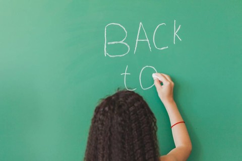 Brunette girl standing chalkboard writing