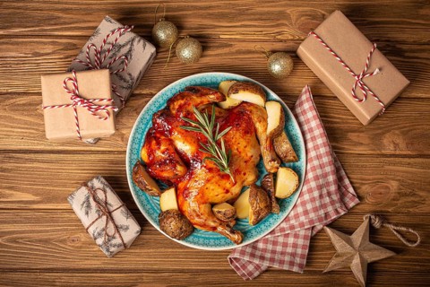 Festive Christmas dinner with roasted whole chicken top view on wooden rustic background with Xmas