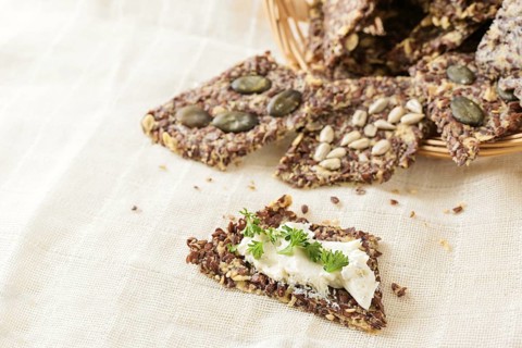 Healthy snacks from linseed, oat, herbs and various seeds, one with cream cheese and parsley