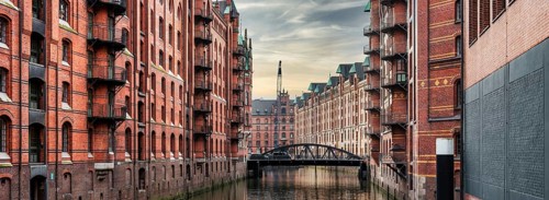 panoramic view of canal and historic buildings in old warehouse district Speicherstadt in Hamburg,