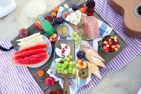 Picnic on the beach at sunset in the style of boho. Food and drink, relax, holiday concept