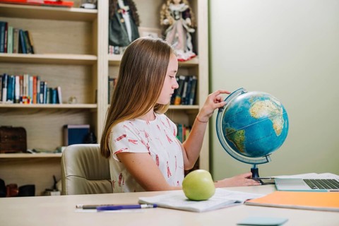 Student posing with globe table