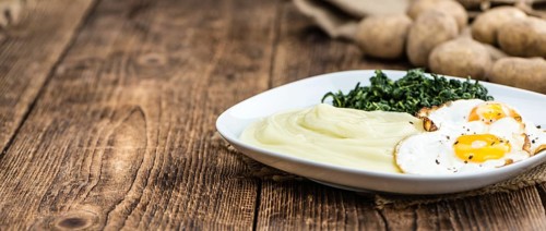 Portion of homemade Mashed Potatoes on wooden background (selective focus, close-up shot)