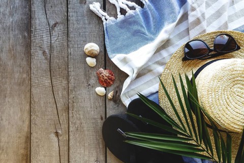 Concept of travel, vacation or weekends. Straw hat with palm leaf, shoes and eyeglasses, towel on