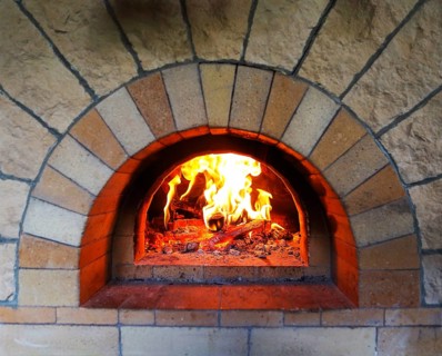 Burning firewood in traditional oven at restaurant kitchen