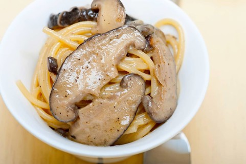 Italian spaghetti pasta and fresh wild mushrooms on rustic wood table