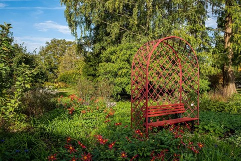 Red bench in the district educational garden, Burgsteinfurt, Münsterland, North Rhine-Westphalia,