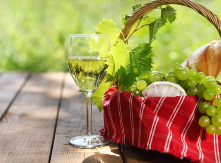 Cheese, grapes, bread and two glasses of the white wine outdoors