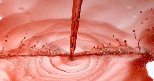 Red Wine being poured against White Background