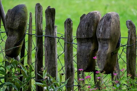 Old clogs on a garden fence