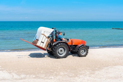 The beach chair rental place their baskets by tractor on the beaches of the Baltic Sea near Graal M