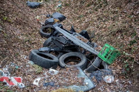 Old used car tires in the forest. Illegal dump of tires in the nature. Environmental pollution