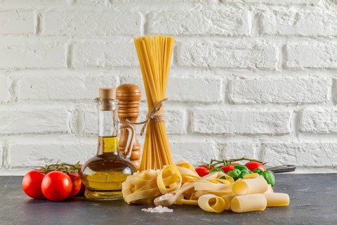 Surface with different types pasta tomatoes oil