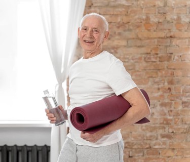 Medium shot senior man holding yoga mat