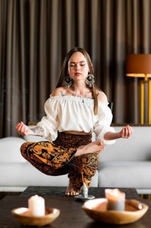 Full shot woman meditating inside