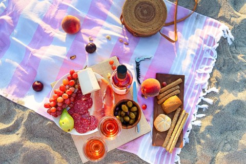Picnic outdoor with rose wine fruits meat and cheese. Sunset