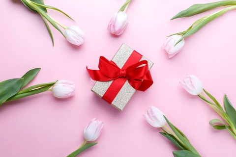 Tulips and gift box on pink background flat lay, romantic card template
