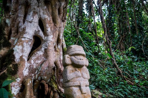San Agustin, Colombia: A mysterious statue of a male person stands in the rainforest next to an old