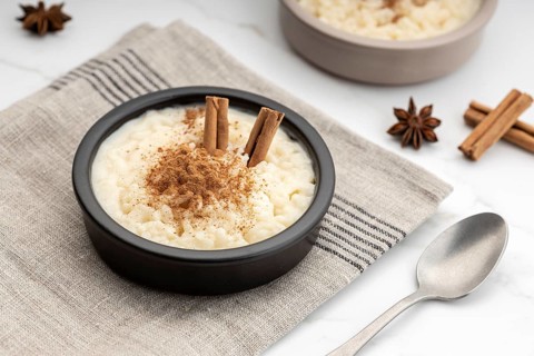 Creamy rice pudding with cinnamon in bowl on white marble table. Typical Spanish dessert