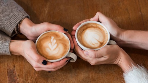 Women holding cups coffee table