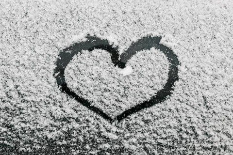 Heart shape snowy glass during winter day