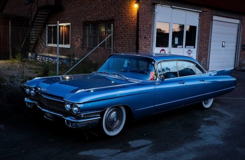 American classic car, blue Cadillac in front of red brick building, industrial area, night shot,
