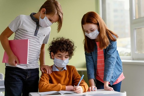 Front view children with medical masks learning school