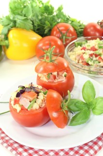 Stuffed tomatoes with pasta salad against a light background