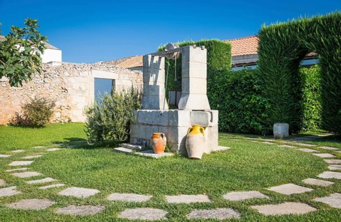 Summer season in Italy. Desing water well in an elegant garden
