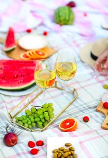 Picnic background with white wine on green grass close-up