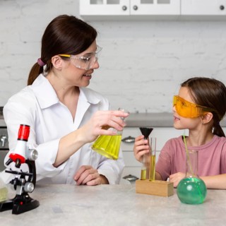 Little girl female teacher doing science experiments with test tubes