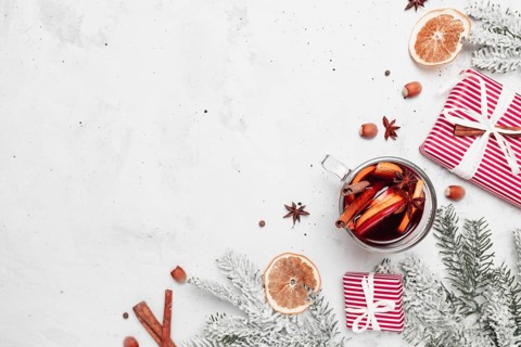 Christmas flat lay top view on white gray concrete background table with glass cup or mug of Mulled