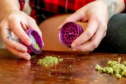 A beautiful brunette model smokes marijuana in the privacy of her own home