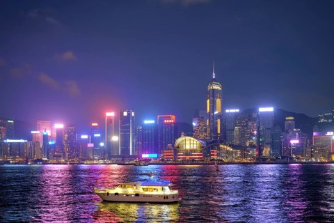 Hong Kong skyline cityscape downtown skyscrapers over Victoria Harbour in the evening illuminated