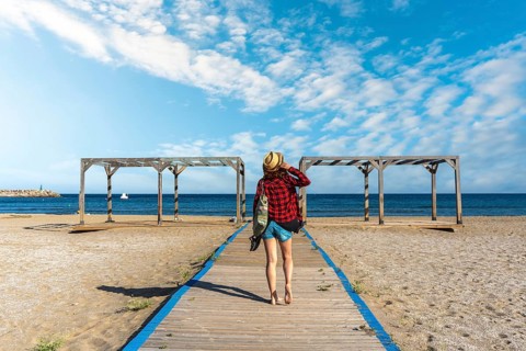 A young tourist on the wooden walkway of San Jose beach in the town of Nijar, Almería. Andalusian