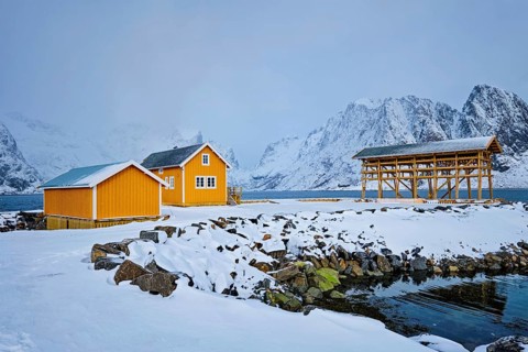 Traditional yellow rorbu house in drying flakes for stockfish cod fish in winter. Sakrisoy fishing