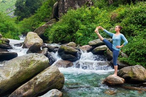 Yoga outdoors, woman doing Ashtanga Vinyasa Yoga balance asana Utthita Hasta Padangushthasana,