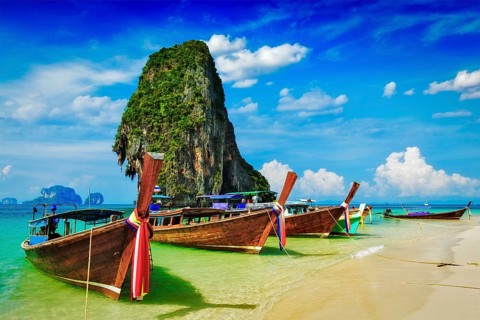Long tail boat on tropical beach with limestone rock, Krabi, Thailand, Asia