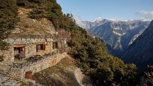 Entrance to the gorge, entrance, ticket office in the rock, terrace, snow-capped mountains,