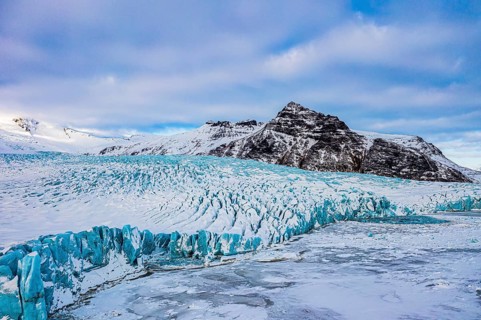 Snow-covered icebergs in the Fjallsarlon glacier lagoon, with the Öraefajökull glacier behind,