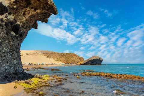 Summer at Monsul Beach in the Cabo de Gata Natural Park, created with eroded lava formations in the