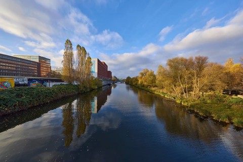 General architecture, trees, canal to the flood basin, blue sky with nimbostratus and cumulus
