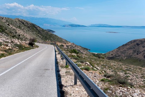 Winding road through mountainous landscape with sea view, mountain road towards Stara Baška, Stara